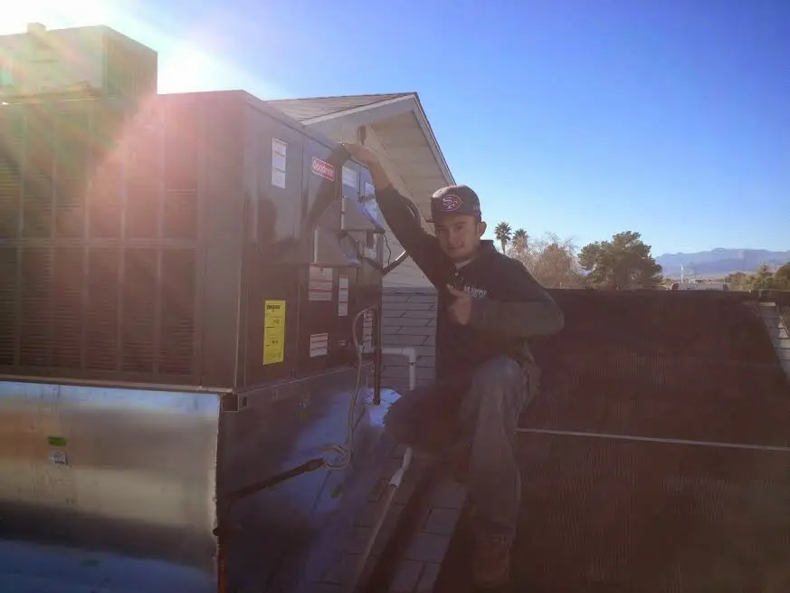 HVAC technician performing AC Tune-Up on a rooftop unit in Pinson
